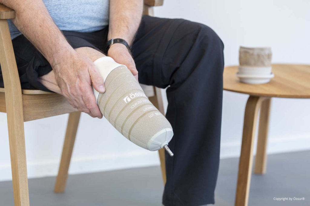 Ein Anwender beim täglichen Anziehen seiner Beinprothese und dem passgenauen Anlegen des Schafts an den Stumpf.